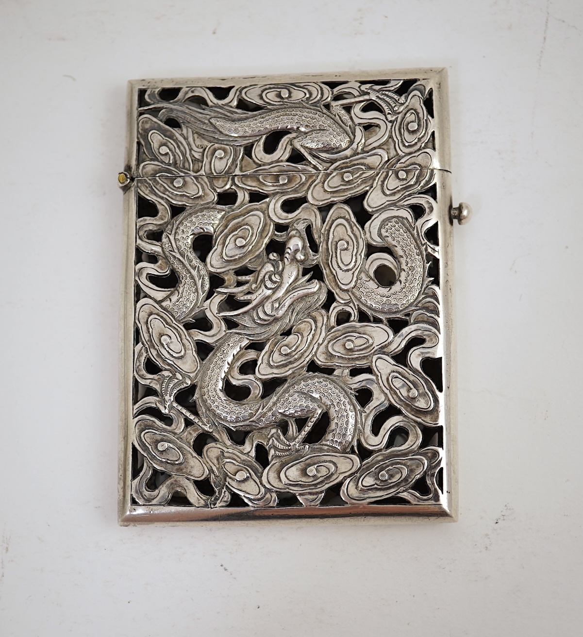 A late 19th century Chinese Export pierced silver card case, maker KMS(Kwong Man Shing), decorated with dragons amid clouds, 10.4cm, together with a Chinese Export pierced silver octagonal box and cover, by Luen Wo?, cir